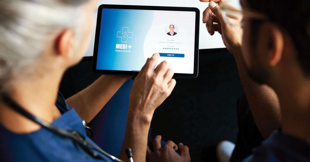 Two doctors using digital tablet for medical records