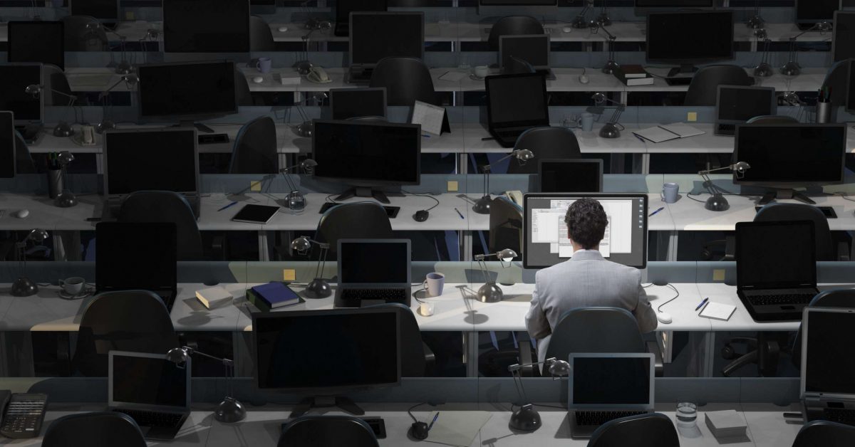 An office worker sits working in an empty office