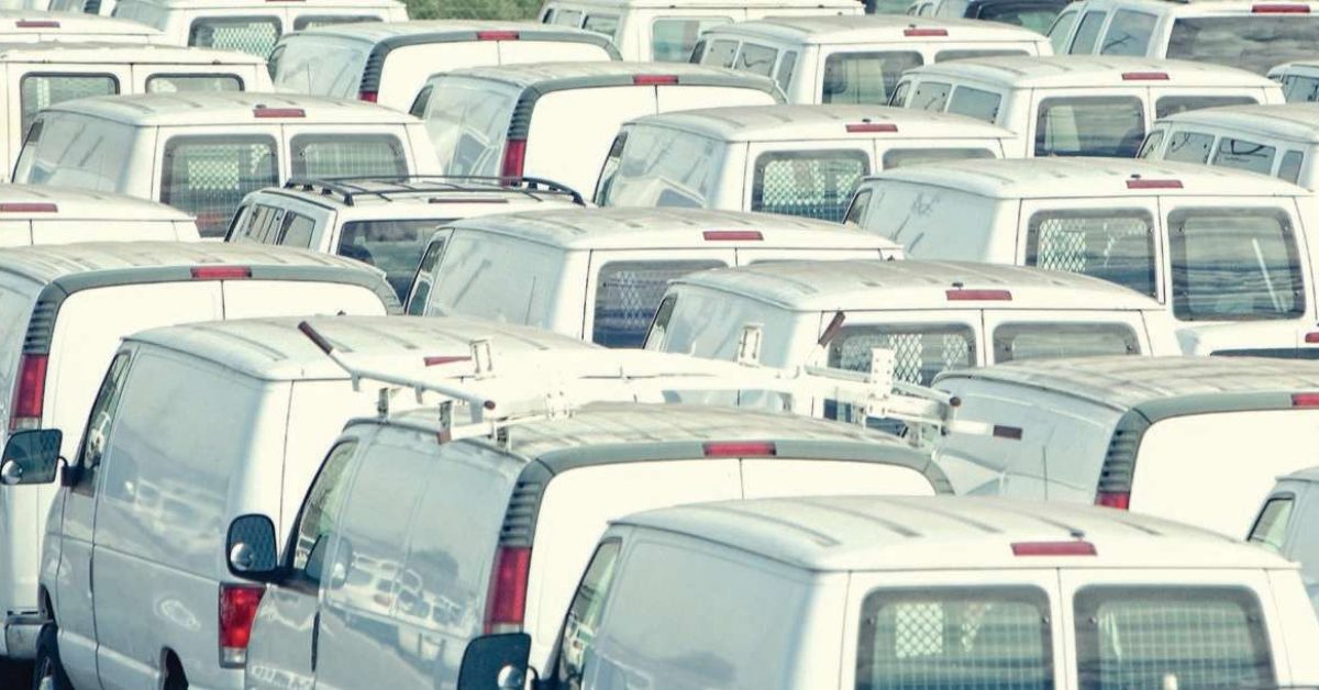 Rows of parked vans in a parking lot.