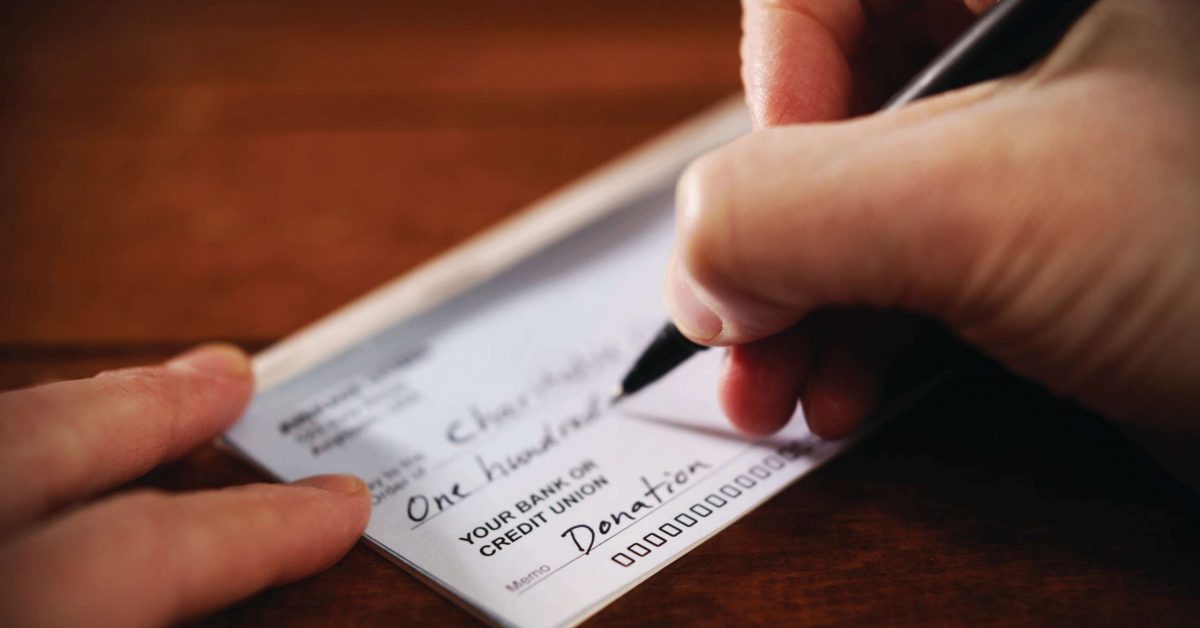 Writing a donation check to a charitable organization