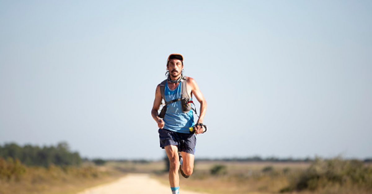 Ultra marathon runner coming towards camera from low angle with copy space.